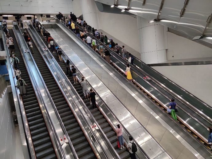 a group of people riding down an escalator